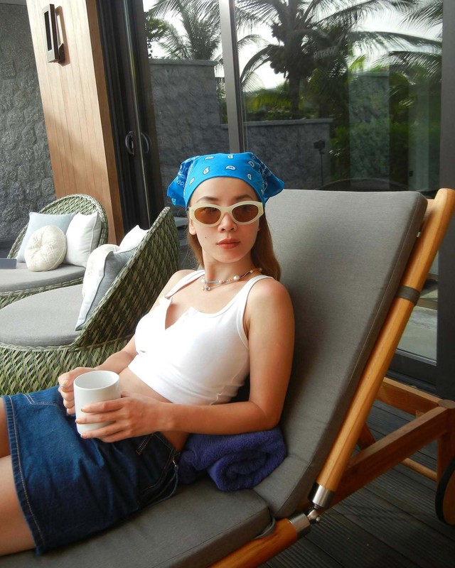 Yến Trang trong set đồ crop top trắng và chân váy denim ngắn.