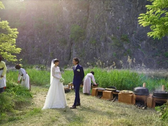 Khách mời và cô dâu, chú rể dùng bữa tại cánh đồng lúa mạch.